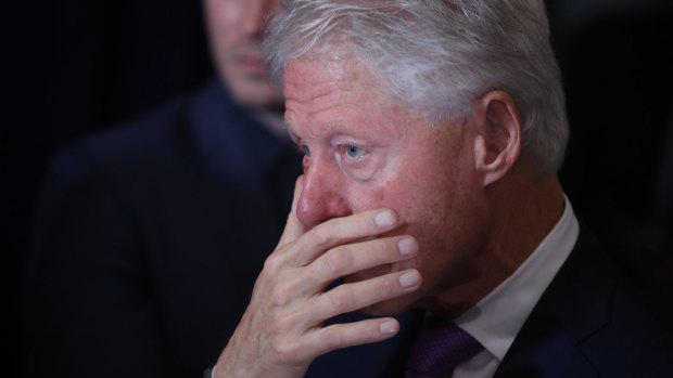 Bill Clinton listens as his wife Hillary Clinton delivers her concession speech in New York.