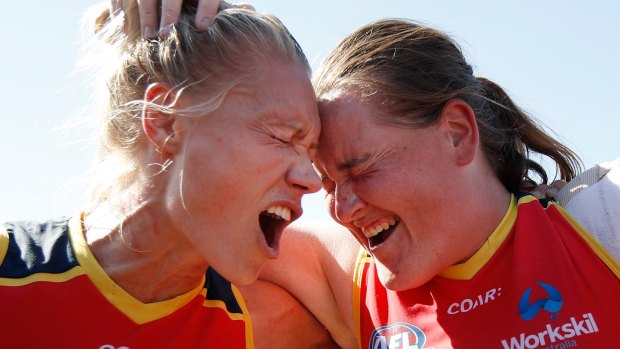 Adelaide's Erin Phillips (left) and Sarah Perkins belt out  the team song after their win against Collingwood on Sunday.