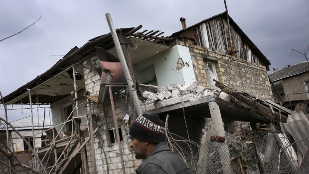 An ethnic Armenian man walks past a destroyed house during the fighting in Martakert province in the separatist region of Nagorno-Karabakh on Monday. 