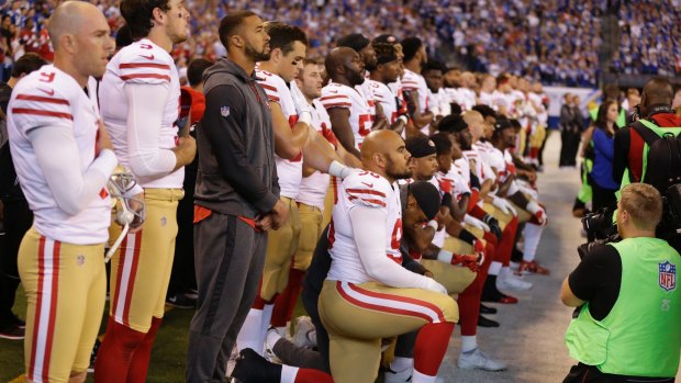 Members of the San Francisco 49ers kneel during the playing of the national anthem before the match against the Indianapolis Colts.