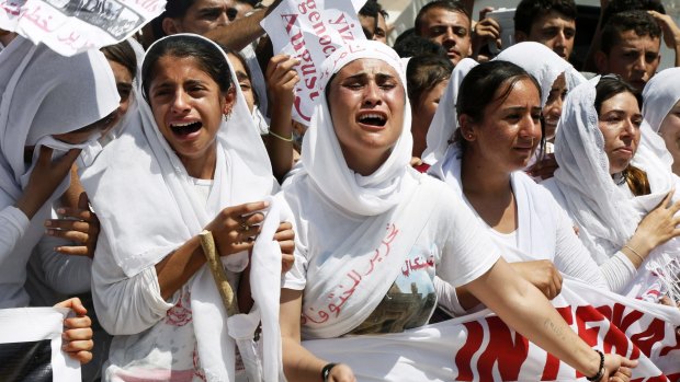 Yazidi Kurdish women chant slogans against the Islamic State's invasion on Sinjar a year ago. Thousands of Yazidi Kurdish women and girls have been sold into sexual slavery and forced to marry IS militants.
