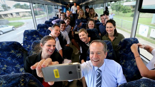 Opposition Leader Bill Shorten takes a selfie with media on the campaign bus on the way to Beaconsfield State School in Mackay, Queensland.