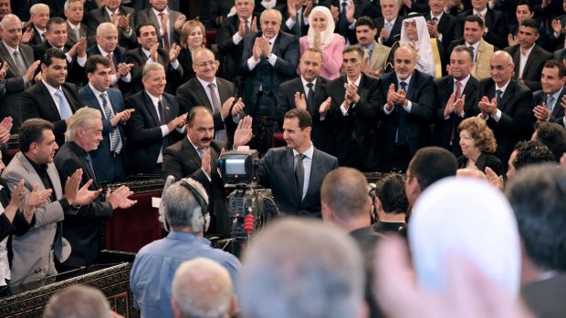 Syrian President Bashar al-Assad waves before addressing the newly-elected parliament in Damascus, Syria.