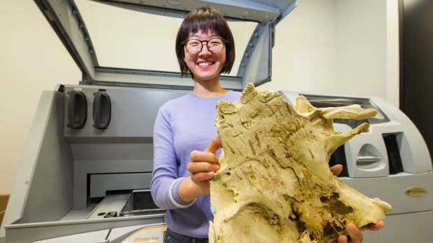 ANU PhD student Yuzhi Hu with a 3D model of a fish fossil created after completing a CT scan on the fossil found near Lake Burrinjuck