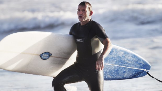 Tony Abbott, pictured surfing in 2014, went to hospital for a "couple of stitches" after encountering rough surf conditions on Friday morning.