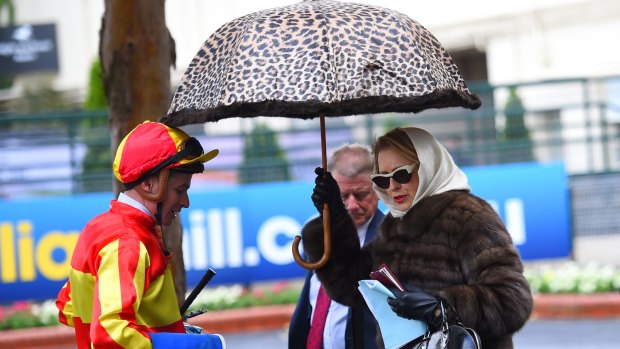 Trainer Gai Waterhouse keeping dry after Race 1 during Cox Plate day at Moonee Valley Racecourse on Saturday.