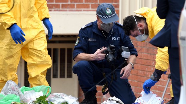 Police examine items outside Khaled Khayat's Lakemba unit as part of their investigation into an alleged terrorism plot.