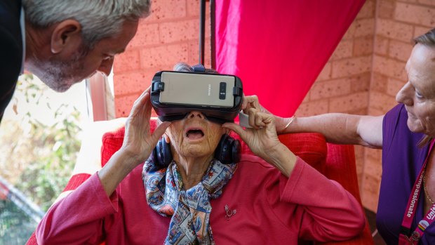 85-year-old Berenice Benson takes a virtual reality tour of New York city with the help of Samsung's Martin Brown and Uniting Mirinjani aged care centre's Jo Sumner. 