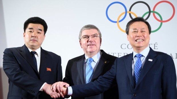 International Olympic Committee president Thomas Bach (centre) shakes hands with representatives from North and South Korea as part of a landmark agreement to undertake Olympic activities together.