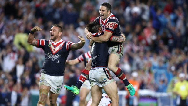 Golden moment: Michael Gordon jumps on Mitchell Pearce in celebration after the Roosters field goal that sunk the Dragons on Tuesday.