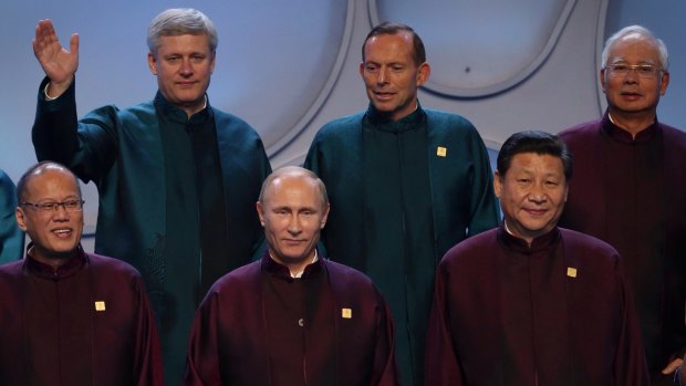 Prime Minister Tony Abbott looks down at Russian President Vladimir Putin during the APEC leader's photo with Canadian Prime Minister Stephen Harper (top left), Philippines President Benigno Aquino (bottom left), Malaysia Prime Minister Najib Razak (top right) and China President Xi Jinping (bottom right).