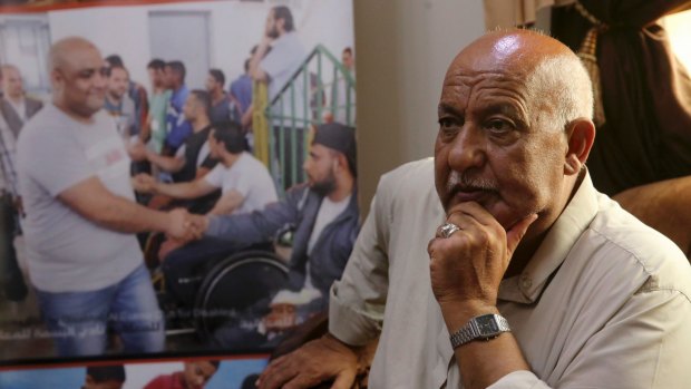 Khalil al-Halabi, 63, the father of Mohammed al-Halabi,  beside a picture of his son at the family home in Gaza City.
