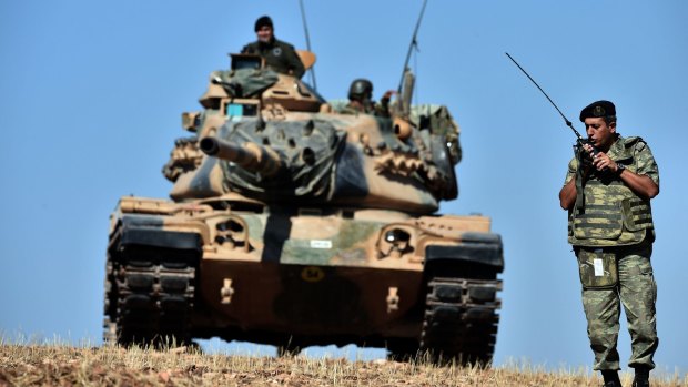 INACTION: Turkish tanks line up on a hill outside the village of Mursitpinar next to the Syrian town of Kobane.