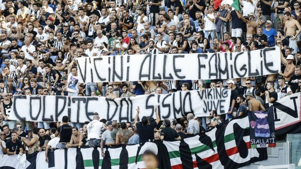 Juventus supporters show a banner reading "Close to the families hit by the earthquake".