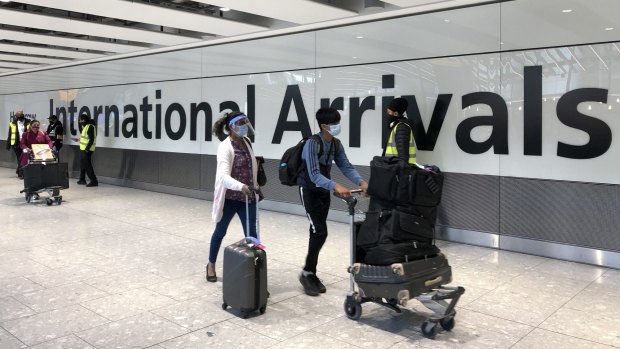 Passengers arrive at London's Heathrow airport. The UK has introduced a 'traffic light' system for dealing with arrivals from different countries. 