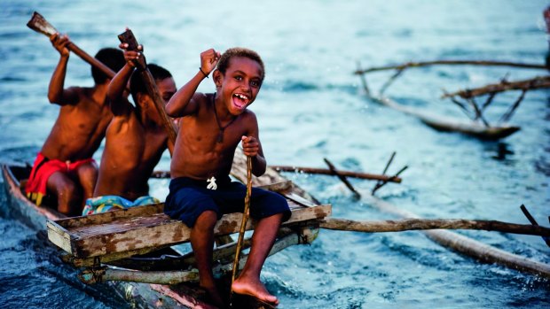 Children in a canoe race in Madang harbour, PNG.
