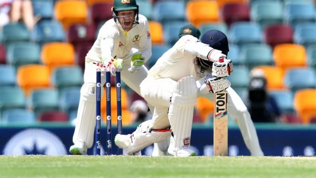 Millimetre perfect: Tim Paine whips off the bails to end Moeen Ali's innings.