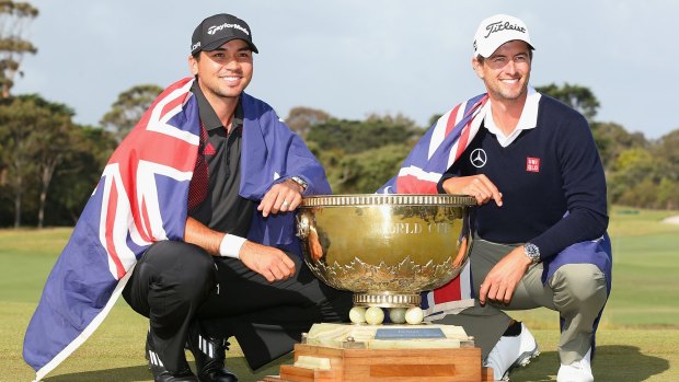 Jason Day and Adam Scott pose with the trophy after winning the teams event of the World Cup of Golf in 2013.