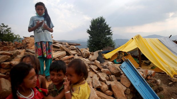 Children stand on the remains of houses which were destroyed in Sindhupalchowk district, Nepal.