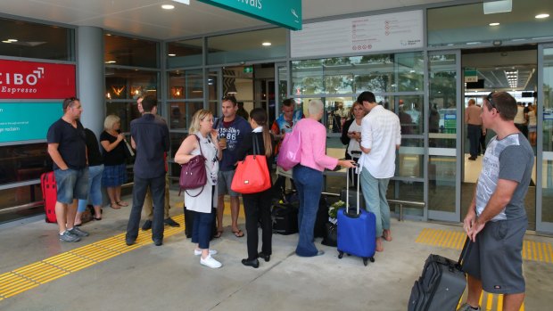 Passengers wait outside the arrivals hall.