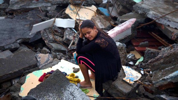 A woman cries amid the rubble of her home, destroyed by Hurricane Matthew in Baracoa, Cuba.