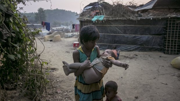 A girl carries a toddler in her arms in Kutapalong Rohingya refugee camp in Cox's Bazar, Bangladesh. 