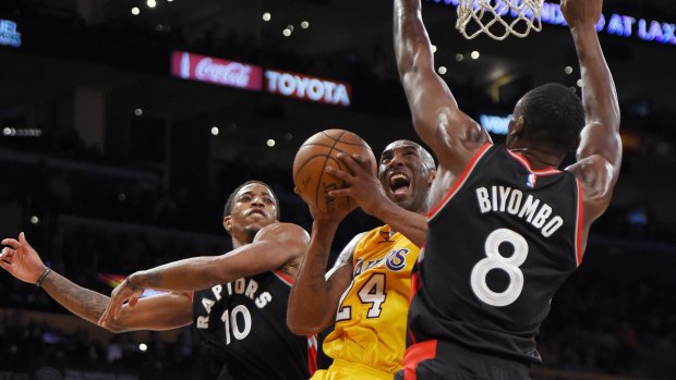 Los Angeles Lakers forward Kobe Bryant (centre) shoots under pressure.