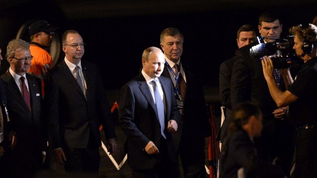 Vladimir Putin is escourted to his armoured vehicle on the tarmac of Brisbane airport.