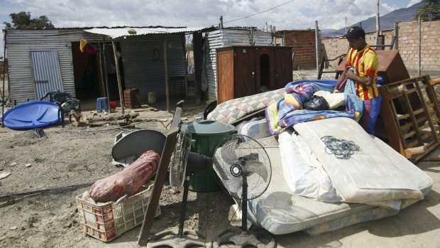 A man stands near houses used by people who do not possess proper documentation in Venezuela.