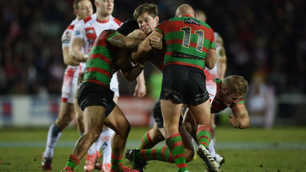 Wrapped up: Louie McCarthy-Scarsbrook is tackled by Glenn Stewart, Issac Luke and Tom Burgess during South Sydney's 39-0 win over St Helens.