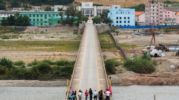 Chinese tourists stand on the Tumen bridge linking China and North Korea, as seen from Yanbian, China.