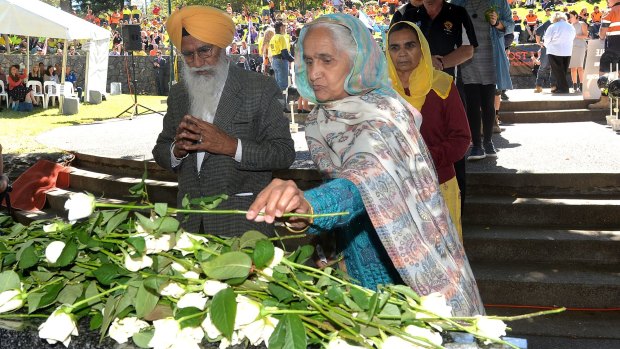 Manmeet Sharma's parents, Ram Sarup and Krishna Devi, lay flowers at a memorial for International Workers Memorial Day.