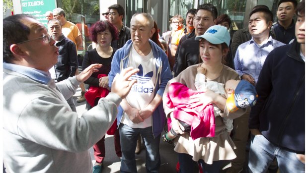 Some of the Chinese workers and their families outside Lendlease's Melbourne offices in Docklands last month.