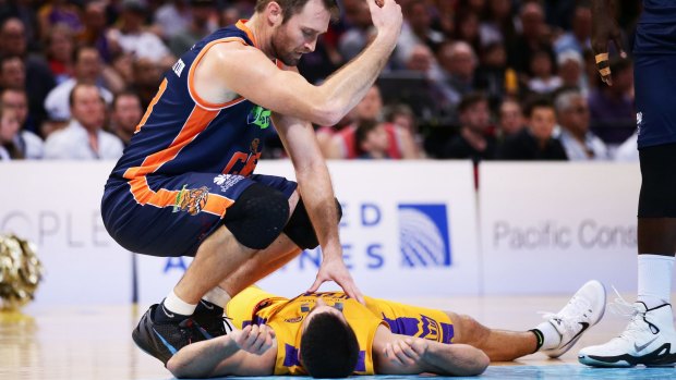 Help coming: Mark Worthington of the Taipans calls for medical help for Kevin Lisch after their collision at Qudos Bank Arena.