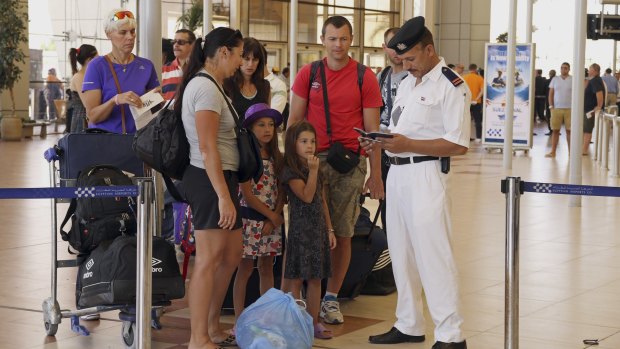 Egyptian police check the documents of British tourist as they prepare to be evacuated from Sharm el-Sheikh airport on Friday.