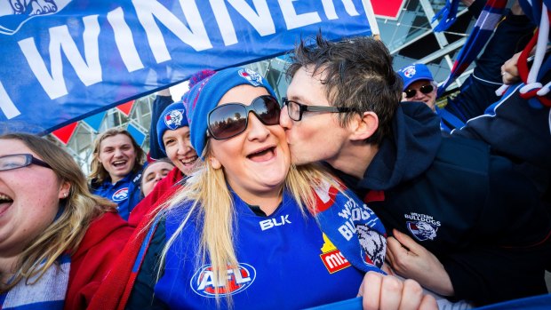 Moore gets a kiss from fellow Bulldogs supporter Chris Patmore at Whitten Oval. 