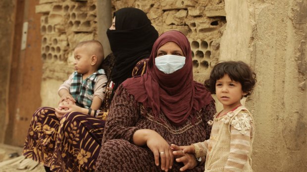 Syrian refugees cover their faces  during a sandstorm in a refugee camp in Lebanon.