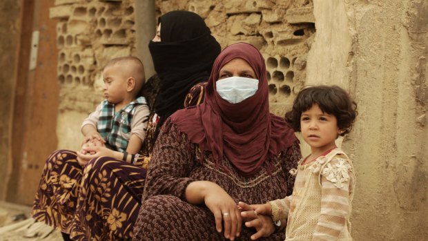 Syrian refugees cover their faces  during a sandstorm in a refugee camp in Lebanon.