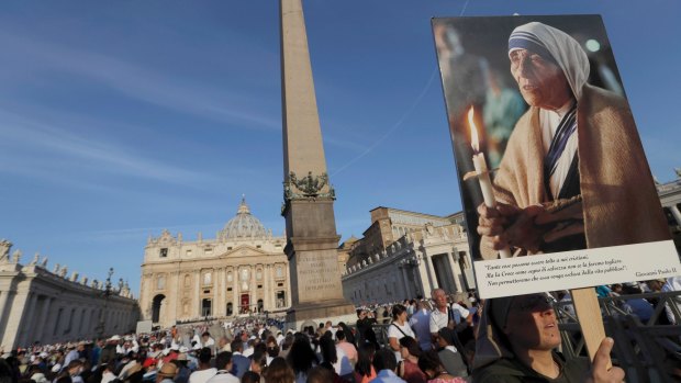 A nun holds a photo of Mother Teresa before the start of the canonisation ceremony in St Peter's Square at the Vatican.