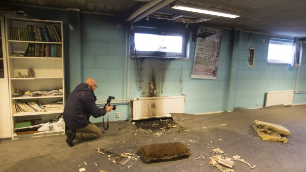 Police officers investigate a suspected arson attack after a fire in a worship room in the southern Swedish town of Eslov.