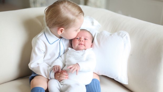 Prince George kisses his baby sister Princess Charlotte.