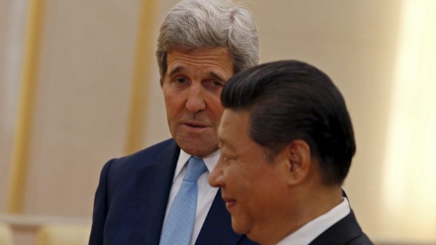 U.S. Secretary of State John Kerry (L) looks at Chinese President Xi Jinping as he introduces his accompanying staff (not pictured) to Xi at the Great Hall of the People in Beijing, China, May 17, 2015.  REUTERS/Kim Kyung-Hoon