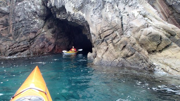 Exploring south coast sea caves by kayak.