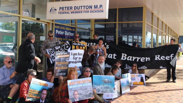 Protesters hold banners outside Peter Dutton's electorate office in Strathpine.