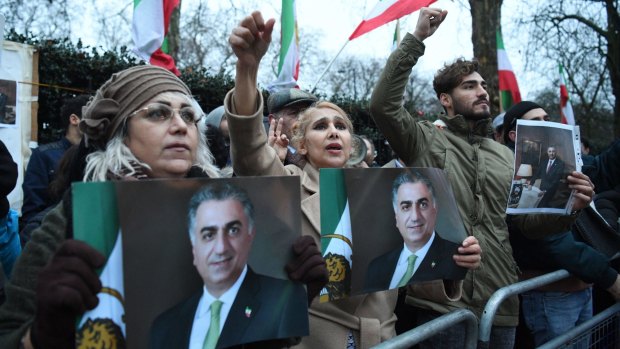 Supporters of Reza Pahlavi, the heir to Iran's deposed monarchy, carry his image during protests outside the Iranian embassy in London this week.