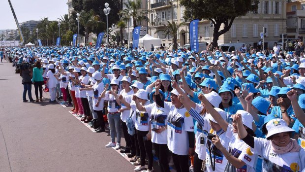 Employees of Chinese company Tiens attend a parade on the Promenade des Anglais in Nice.