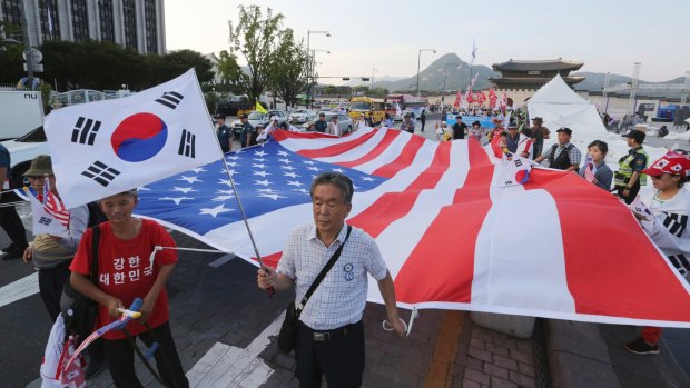 Supporters of former South Korean President Park Geun-hye march with a US flag during a rally to call for her release and to oppose South Korean President Moon Jae-in's North Korea Policy.
