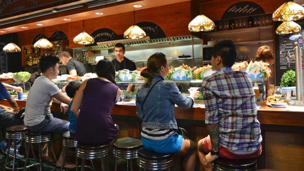 Barcelona: customers seated at a tapas bar at La Boqueria market in Barcelona, Spain. 