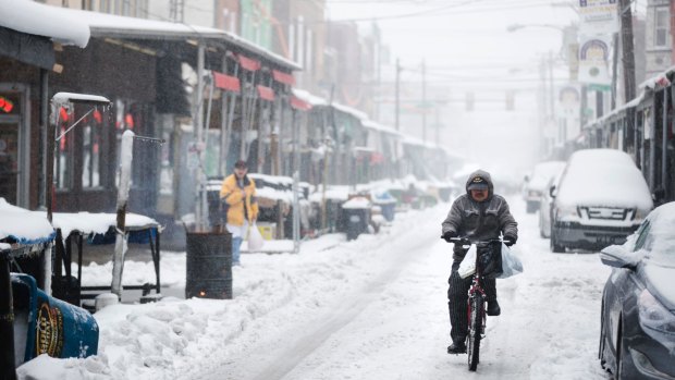 A man rides his bicycle through the Italian Market neighbourhood of Philadelphia on Tuesday.