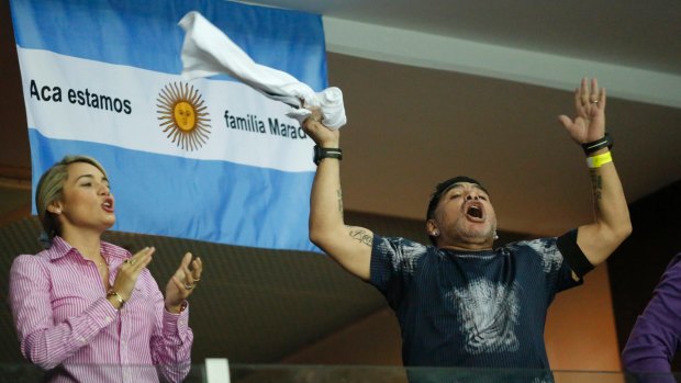Party time: Argentinian football legend Diego Maradona cheers from the stands.